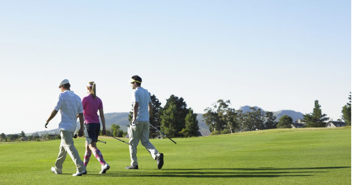 drie wandelende mensen tijdens het golven